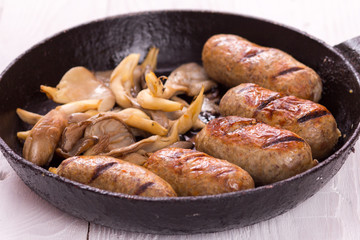 sausage and mushrooms in a frying pan