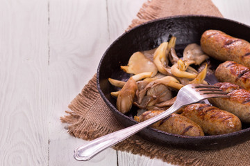 sausage and mushrooms in a frying pan