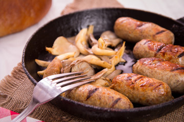 sausage and mushrooms in a frying pan
