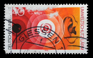 Obraz premium Stamp printed in the Germany shows Environment Emblem and Noise Pollution, Nature and Environmental Protection, circa 1973