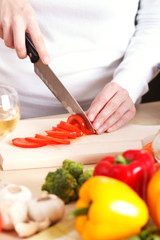 Close-up of female cutting vegetables on a kitchen cutting board