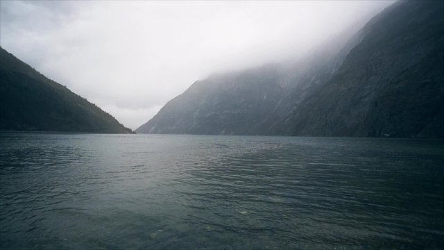 Norwegian fjords and mountains. Misty shore and waves