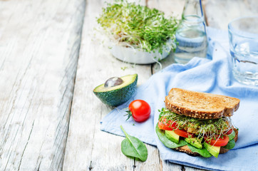 sprouts avocado tomato spinach chickpeas burger rye sandwich