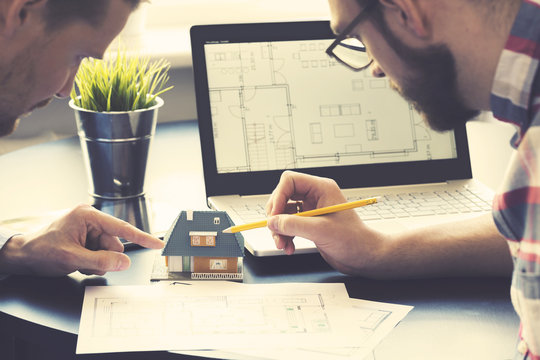 Architect Showing New Family House Model To Customer At Office