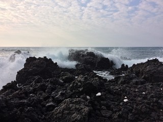 Ocean Waves Splashing Over Lava Rocks