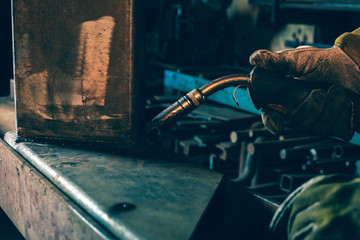 Hand of welder holding welding device