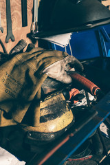 Safety welding gloves lying on mask - obrazy, fototapety, plakaty