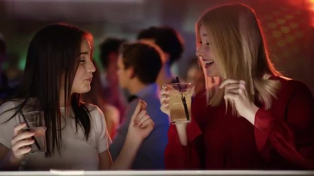 Two girls having drinks in club
