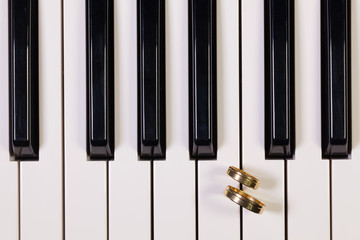 Naklejka premium Piano keyboard and wedding rings