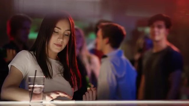 Young woman checking her phone at bar