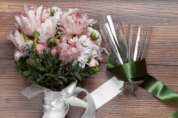 Valentine flowers with wineglasses on wooden background