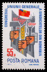 Stamp printed in Romania shows Trade Union Congress  Fists with hammer, ear and torch, circa 1971.