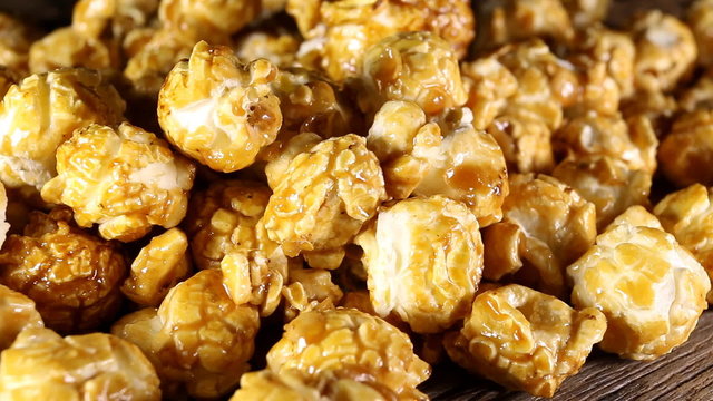 Sweet caramel popcorn on wooden background. Macro shot.