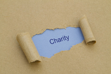 Charity word written under torn paper.