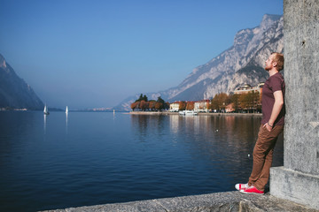 man stands on the promenade overlooking the city of mountain Lake Como