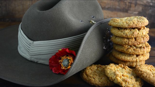 Anzac Day Australian army slouch hat with traditional Anzac biscuits close up, placing the last biscuit.