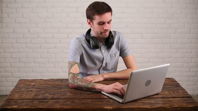 Man-freelancer got bored about his work on laptop at the table