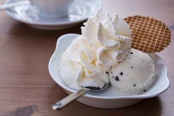 vanilla ice cream ball with whipped cream and biscuit in a bowl