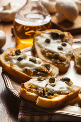 Crostini with fried mushrooms, onion and mozzarella cheese
