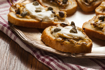 Crostini with fried mushrooms, onion and mozzarella cheese