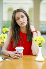 Happy Beautiful brunette girl sitting in a coffee shop