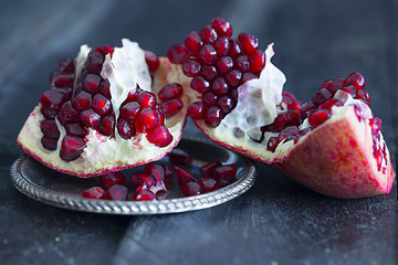 Granatapfel auf einem Teller auf hölzernem Untergrund