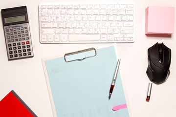 weißer Schreibtisch in Draufsicht mit Tastatur, Taschenrechner, Maus, Stift und 