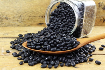 Fototapeta na wymiar dry black beans in bottle and spoon 