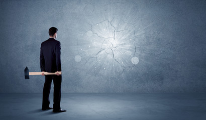 Obraz premium Business man hitting wall with a hammer