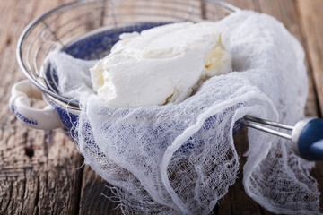 Homemade cottage cheese in a cheesecloth and sieve.Healthy food.selective focus.