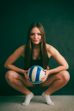 Young woman wear sportswear and hold ball.