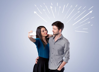 Cute couple taking selfie with arrows