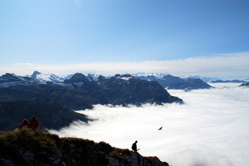 Hikers over sea of fo and mountain range