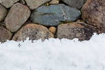 stone wall with snow pile