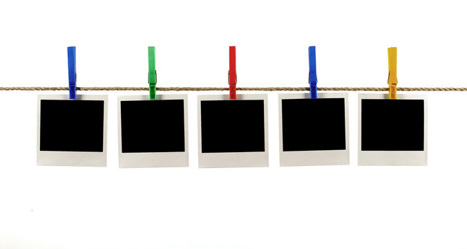 Several five blank polaroid style instant photo print frame straight row hanging on string rope washing line or clothesline isolated on white background