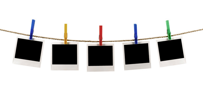 Several five blank polaroid style instant photo print frame row hanging on string rope washing line or clothesline isolated on white background