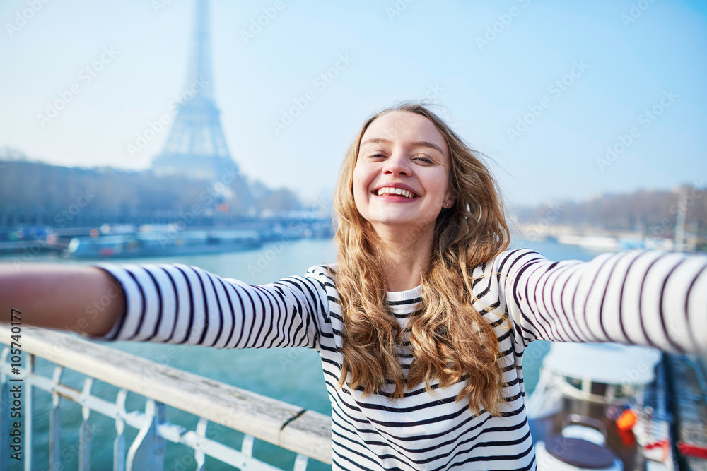 Wall mural beautiful young girl taking funny selfie in paris