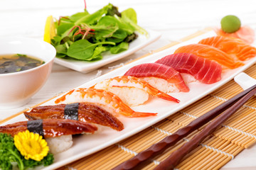 Selection of sushi plate with chopsticks on mat
