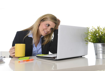 happy blond business woman working on computer at office desk smiling