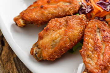 Buffalo chicken wings on white plate wooden background