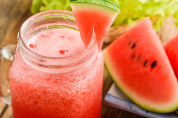 Healthy watermelon smoothie on a wood background and slices of w