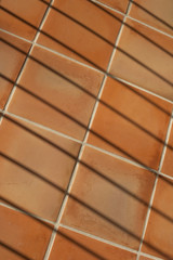 Abstract composition with terracotta tiles and fence shadows