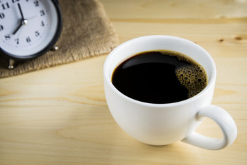 Black coffee in cup of coffee on wooden background