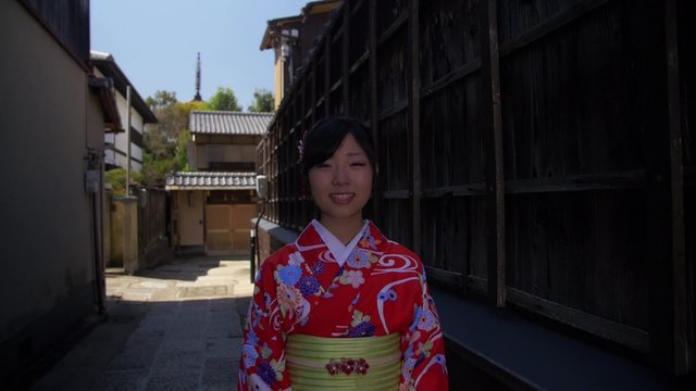 Beautiful young Japanese Girl wearing Kimono walks down Kyoto street 