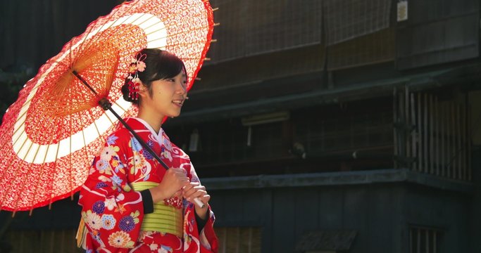 Beautiful young Japanese Girl wearing Kimono explores Kyoto turns to the camera