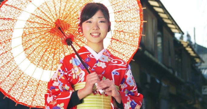 Beautiful young Japanese Girl wearing Kimono Spins old parasol close up