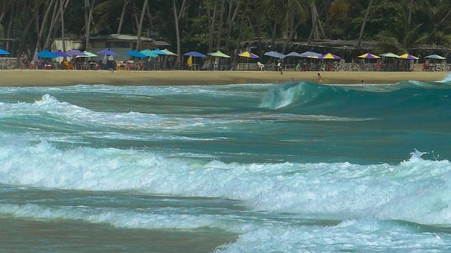 Big waves hitting a tropical Caribbean beach in slow motion