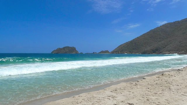 Big waves hitting a tropical Caribbean beach in slow motion