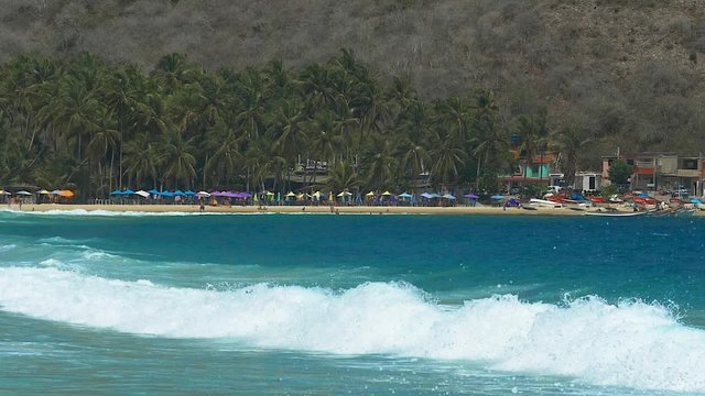 Big waves hitting a tropical Caribbean beach in slow motion
