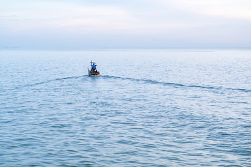 Fototapeta na wymiar Fisherman on a boat heading out to the sea